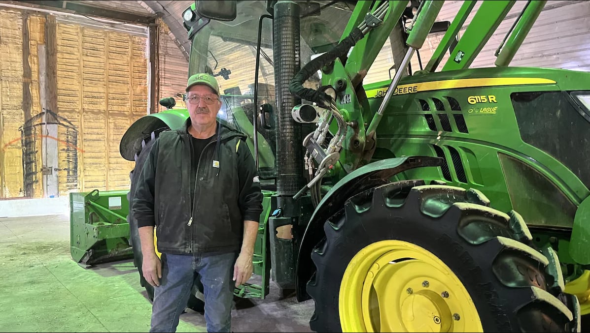 Image 5: The vice-president of the Union of Franco-Ontarian Farmers stands in front of a farming vehicle.