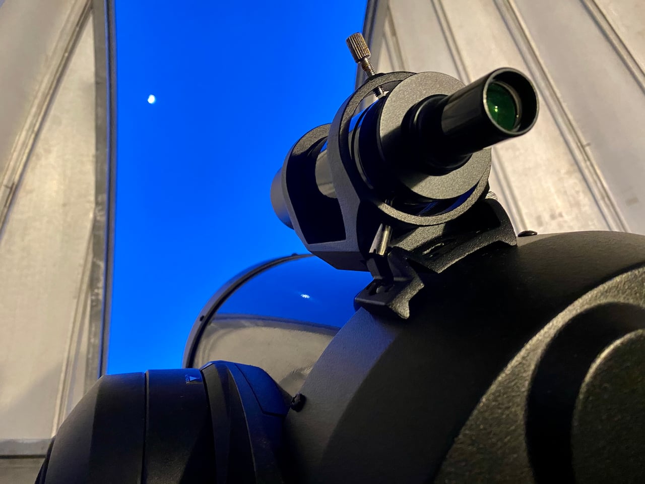 Image 6: A picture of a observatory, the telescope is peaking out of the building, looking into the night sky.