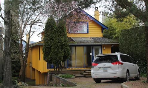 Image 5: A large yellow house is seen with multiple levels.
