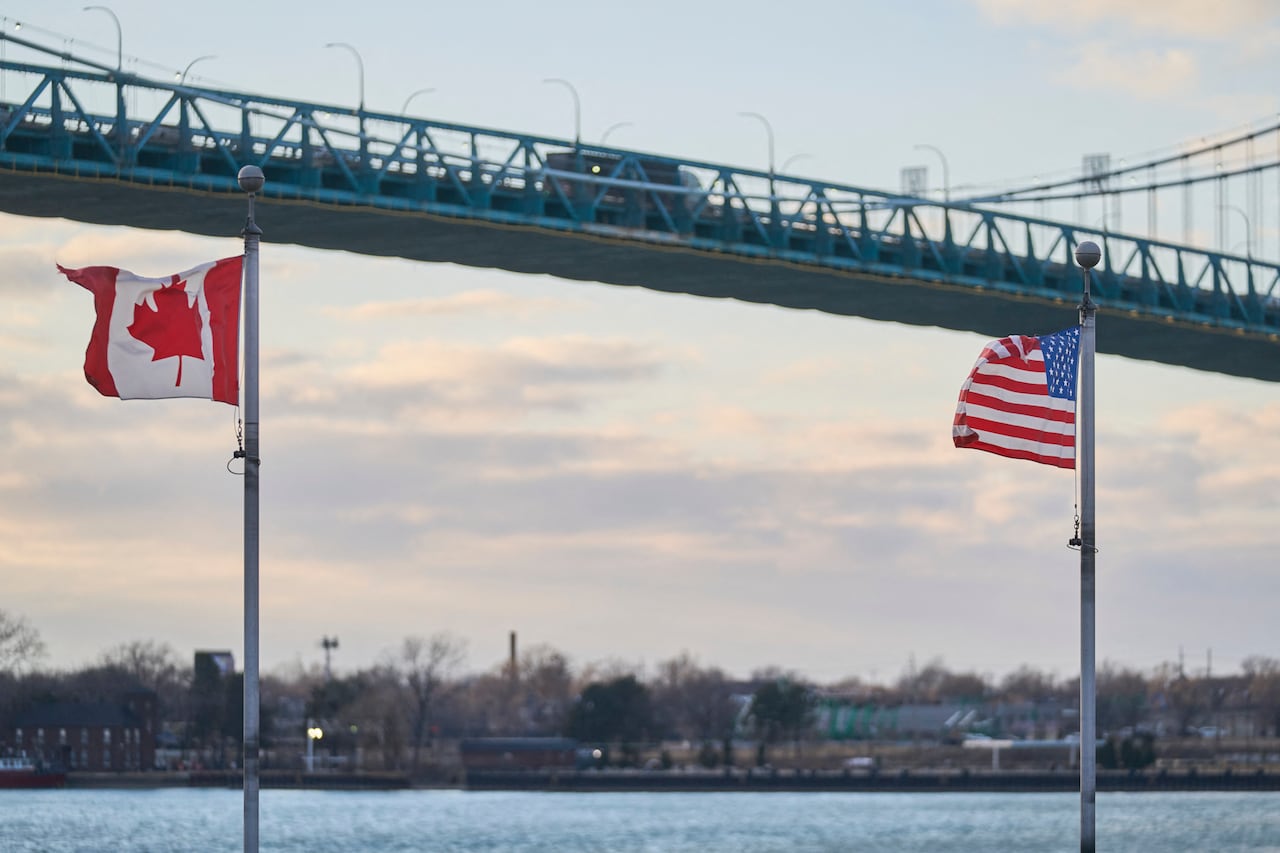 Image 5: A truck crosses the Ambassador Bridge, border crossing between Windsor, Ontario, Canada, and Detroit, Michigan, above the Canadian Vietnam Veterans Memorial on March 1, 2025.